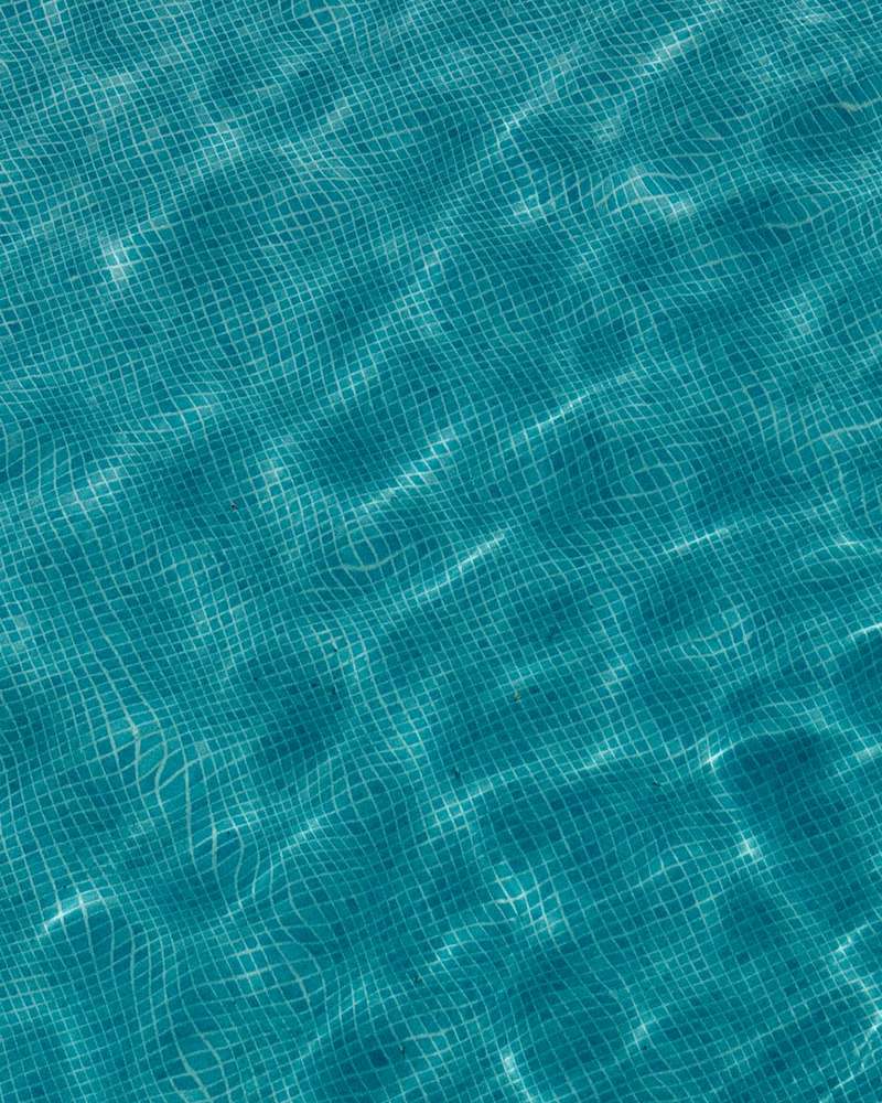 Agua clara de una piscina sobre el gresite